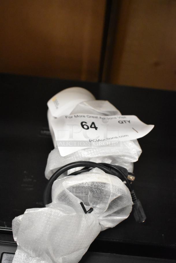 Qsee QCA8075B security camera, packed in bubble wrap, auction tag 64 visible. Condition unknown, cables included.