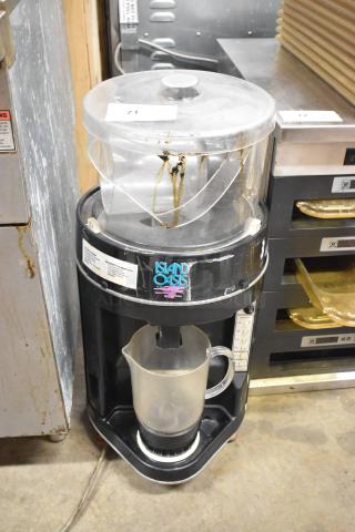 Island Oasis metal countertop frozen drink blending machine, used condition, includes lid and pitcher, visible wear on exterior.