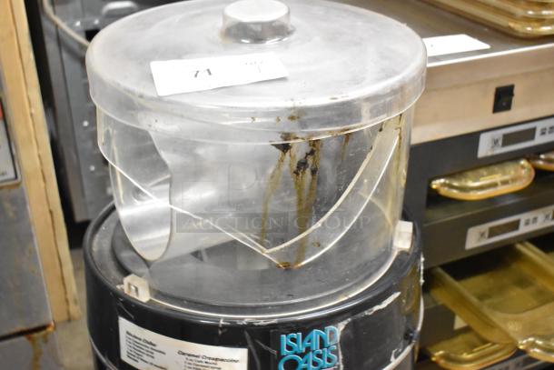 Island Oasis metal countertop frozen drink blender, visible signs of wear, includes transparent lid, brand label, and number tag.