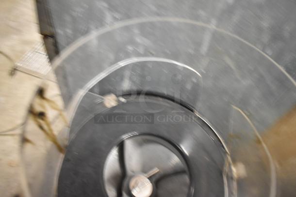 Blurry image of a metal blending machine, possibly used for frozen drinks. Specific details are unclear.