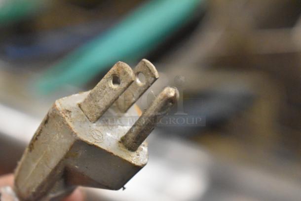 Close-up of a rusty power plug for an Island Oasis Metal Countertop Frozen Drink Blending Machine.