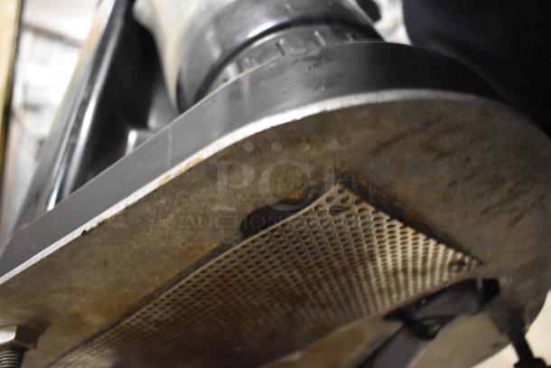 Island Oasis metal countertop frozen drink blender, close-up of the blending surface. Signs of wear visible.