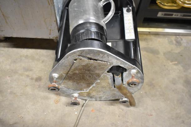 Island Oasis metal countertop frozen drink blender, worn condition, visible base rust, black and silver design.