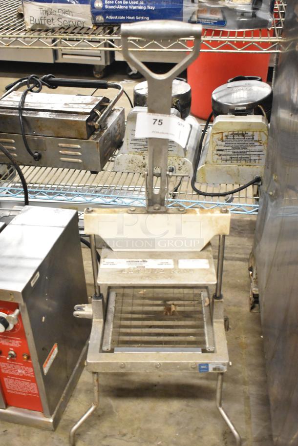 Metal countertop lettuce head cutter with lever handle. Features a grid blade for slicing. Visible label indicates auction item number 75. Used condition.