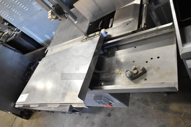 Alt text: Metal commercial floor-style meat saw with a stainless steel body, powered by 208/240 volts, 3-phase.