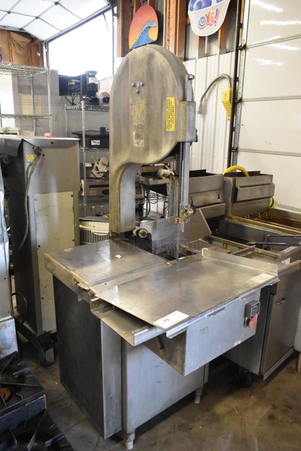 Metal commercial floor-style meat saw, 208/240 volts, 3 phase. Heavy-duty design with stainless steel table, used condition.