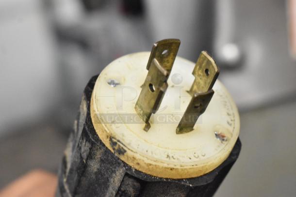 Varimixer W60P power plug, 208V, 3-phase. Close-up of metal prongs and white plastic base with wear marks.