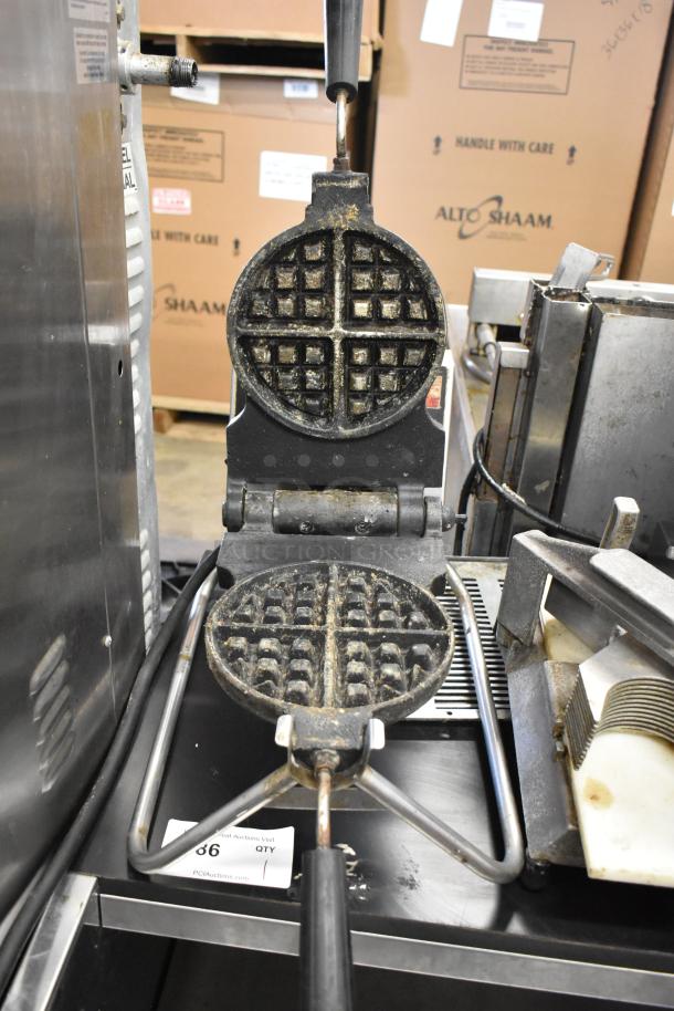 Metal commercial countertop waffle maker, 115 volts, 1 phase. Used condition, visible wear in waffle grids.