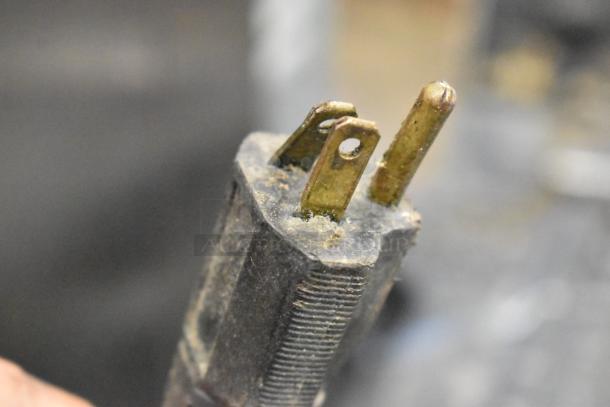 Close-up of a used, slightly corroded plug for a metal commercial countertop waffle maker, 115 volts, 1 phase.