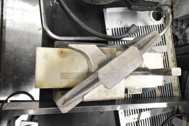 Nemco tomato slicer, stainless steel, used condition, visible Nemco label, suitable for commercial kitchens.