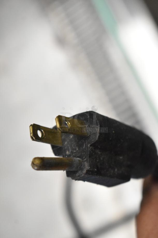 Close-up of a three-prong electrical plug from a metal commercial grab-n-go merchandiser, 115 volts, 1 phase.