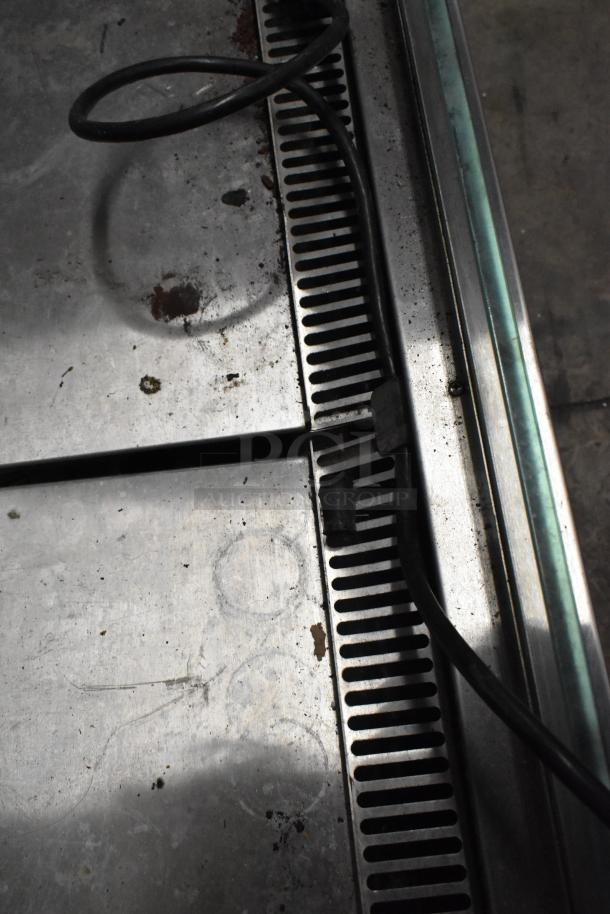 Metal commercial floor horizontal Grab N Go merchandiser, showing rust and dirt. 115 volts, 1 phase. Vent and power cord visible.