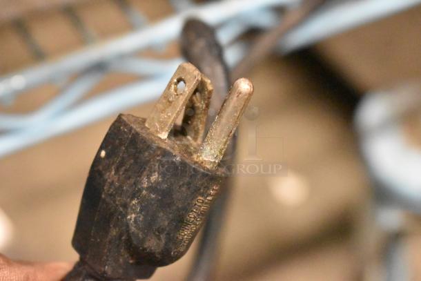 Close-up of a power plug for the Adcraft SG-811 Panini Press, showing signs of wear. Labels indicate connection requirements.