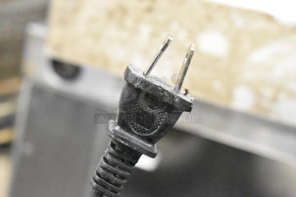 Close-up of a two-prong plug for the Bella Metal Countertop Waffle Maker, 120 Volts, 1 Phase.