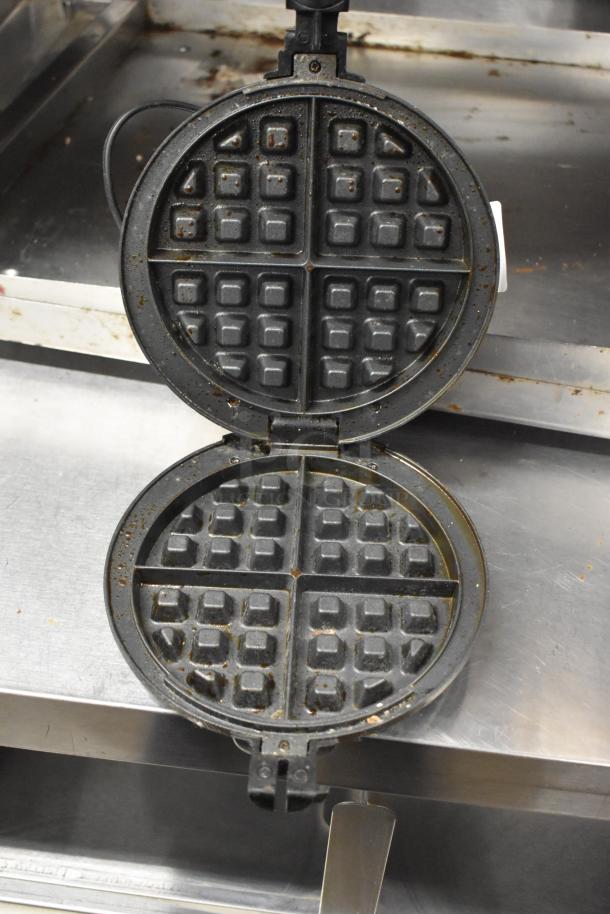 Bella Metal Countertop Waffle Maker, showing interior grid, in used condition. 120 Volts, 1 Phase, black finish.