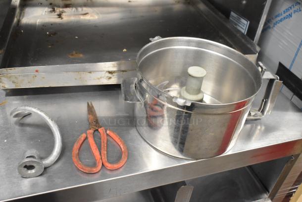 Metal food processor bowl with S blade, dough hook attachment, and red-handled scissors. Used condition.