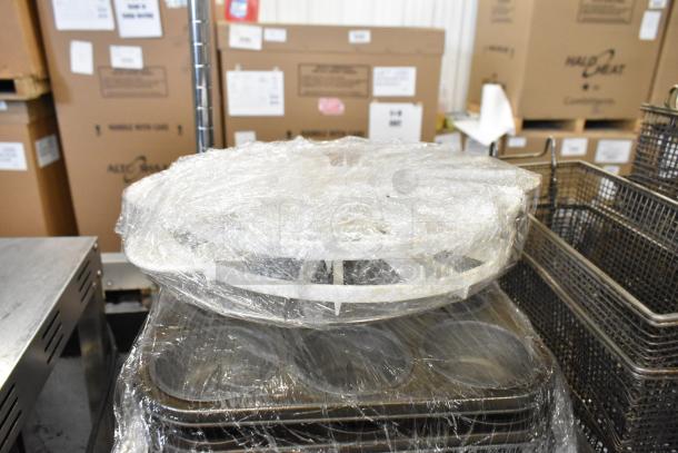 Tiered lot including metal fry baskets and muffin baking pans, wrapped in plastic. Good condition, ideal for baking and frying needs.