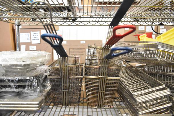 Metal fry baskets with colored handles and stacked muffin baking pans, wrapped in plastic, on metal shelves.