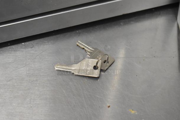 Two metal keys on a silver surface, marked "WESTO" and "Taiwan," associated with non-locking shadowboxes.