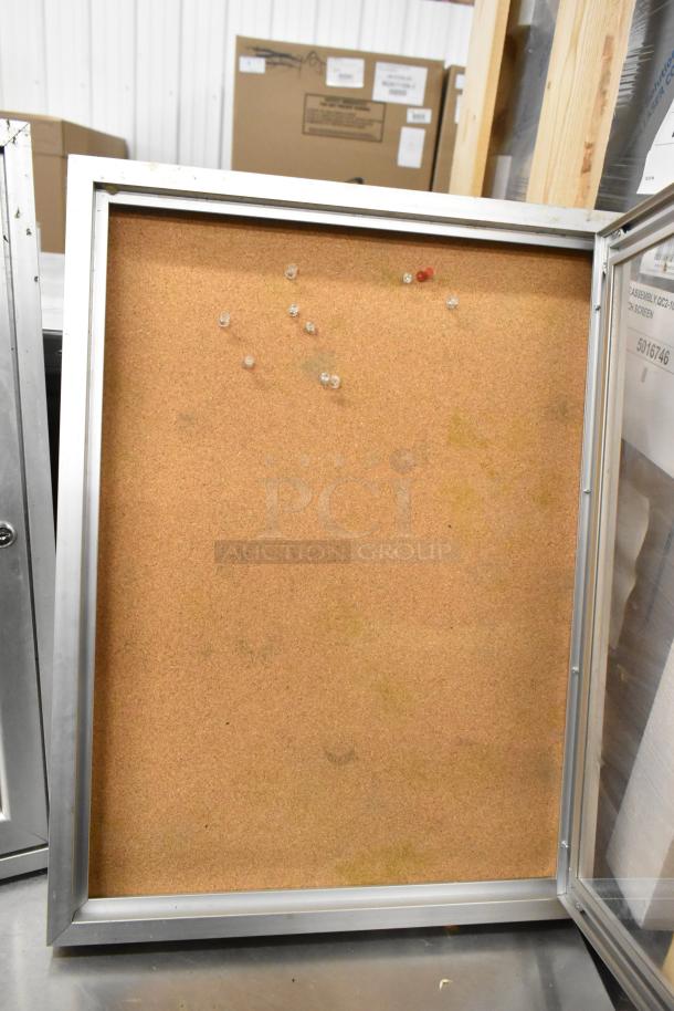 Two metal-framed shadowboxes with cork backing, missing locks, in used condition, several push pins visible.