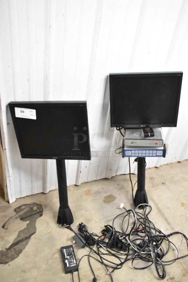 Two Acer V173 monitors on stands, with assorted cables and power adapter. One monitor has a sticker marked "99 V X Z." Monitors appear used.