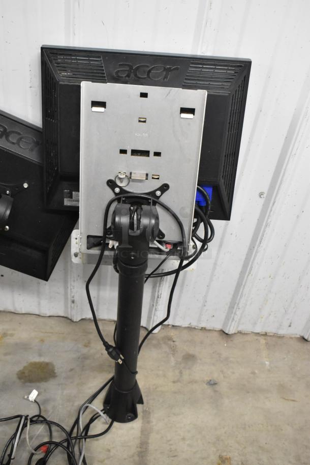 Two Acer V173 monitors, mounted on a stand, with visible cables. Monitors in used condition.