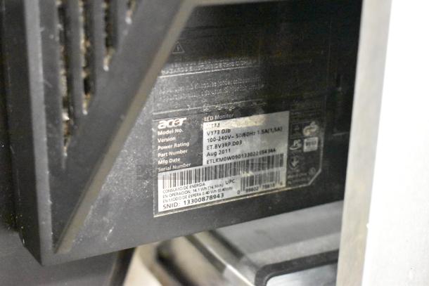 Two Acer V173 monitors with model label showing version V173 Djb, power rating, and August 2011 manufacturing date.
