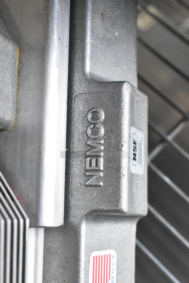 Nemco 56600 metal countertop tomato slicer with embossed branding and NSF certification label visible. Made in USA.