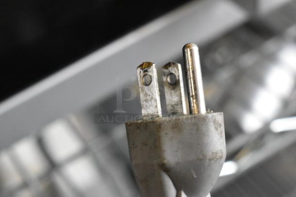 Close-up of a power plug for a Galaxy 177MW1000PD microwave oven, featuring slight wear and dirt.