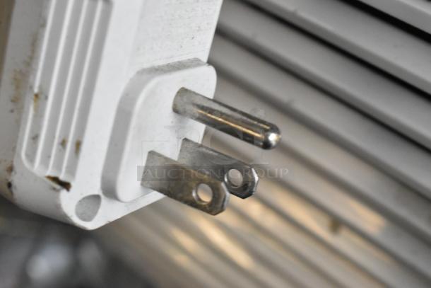 Arctic King window mount air conditioner plug, 115 volts, 1 phase, showing slight wear, against appliance background.