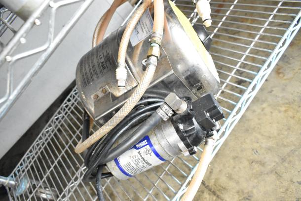 Shurflo Water Booster, 115V, 1 Phase, silver and black, with attached hoses, used condition.
