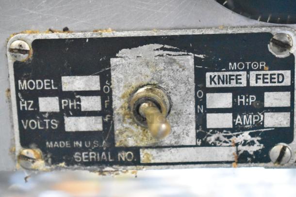 Globe stainless steel commercial countertop meat slicer, 115 volts, 1 phase. Features visible wear, toggle switch, and label.