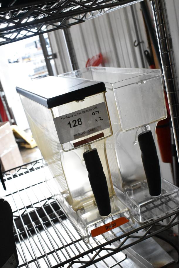 Two clear poly coffee bean grinder hoppers, one missing a lid. Black handles, label reads "Decaf." Auction tag shows quantity 2.