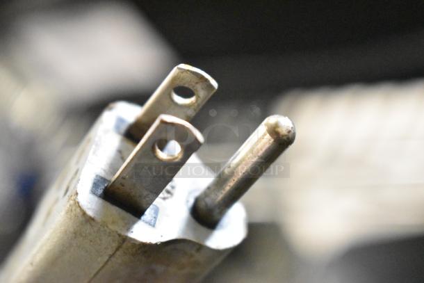 Close-up view of a metal plug, likely part of the Magister M MD LA espresso grinder, indicating 115 Volts, 1 Phase power.