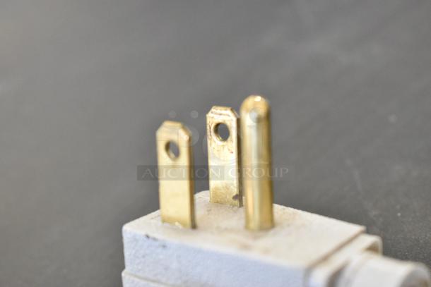 Close-up of a three-pronged electrical plug for a True GDM-41SL-54-LD cooler, showing brass contacts and white casing.