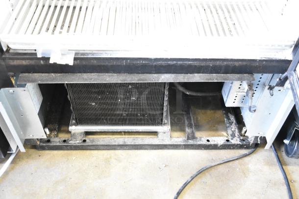 True GDM-26 commercial cooler base with poly-coated racks, visible metal components, and electrical connections.