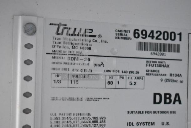 True GDM-26 commercial cooler label showing model, serial number 6942001, 115 volts, 1 phase, R134A refrigerant.