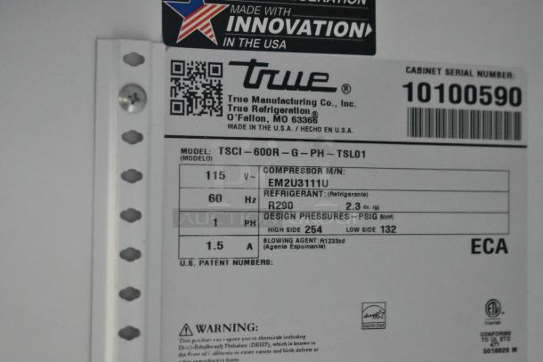 Label on a True TSCI-600R-G-PH single door reach-in cooler showing model, voltage, refrigerant type, and serial number.