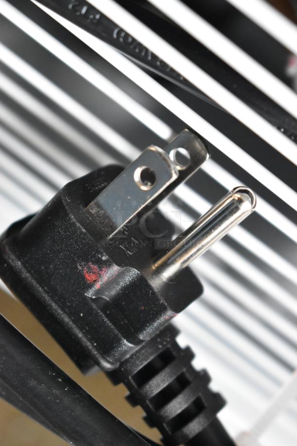 Power plug of KoolMore KM-MDR-1GD-10C display refrigerator, 115V, 1 phase. Metal prongs shown, close-up view.