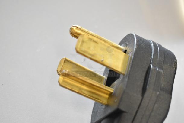 Close-up of a three-prong electrical plug, part of the Crossover 2.0 Metal Front Load Washer, brand new with minor scratches and dents.