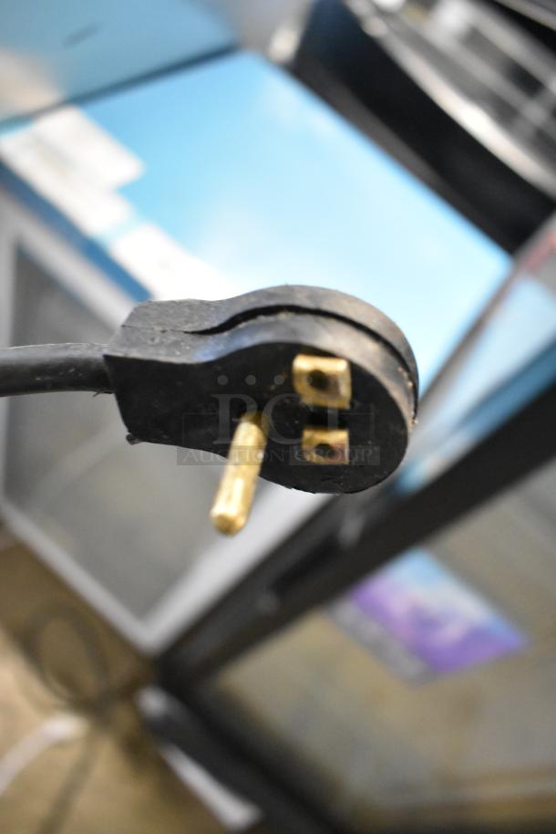 Imbera VRS05 cooler plug close-up, showing a 115-volt connection. Black, three-prong design, indicating electrical setup.