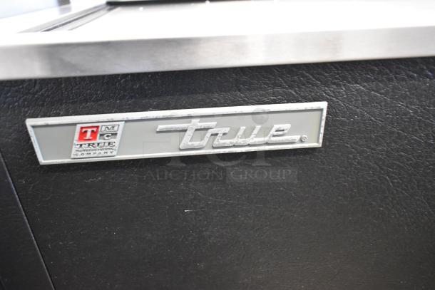 2017 True TD-65-24 metal back bar cooler with 2 sliding lids, on commercial casters. True logo indicating brand authenticity.