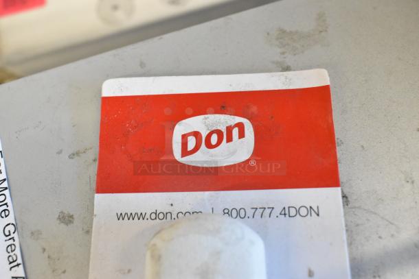 "Don" sticker exhibits brand name and contact details on slightly worn surface, adjacent to auction items.