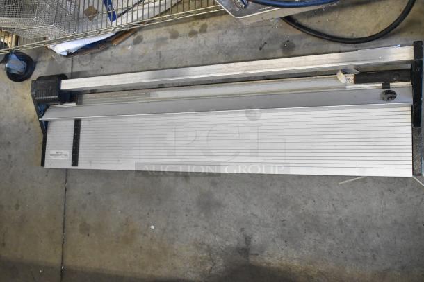 Metal tile cutter with adjustable guide, sturdy build, good condition, measuring scale visible for precision.