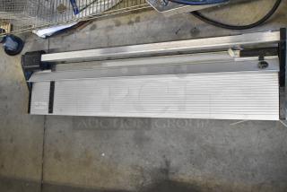 Metal tile cutter with adjustable guide, sturdy build, good condition, measuring scale visible for precision.