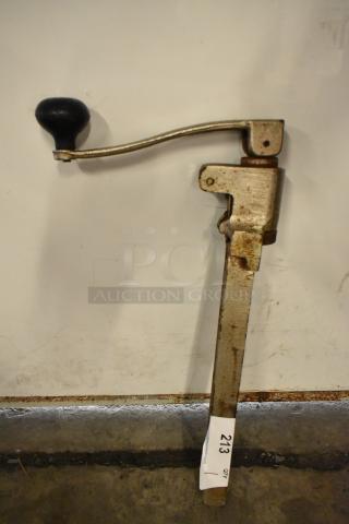 Metal commercial can opener with long handle and sturdy build. Slight wear, tag reads "213." Ideal for heavy-duty use.