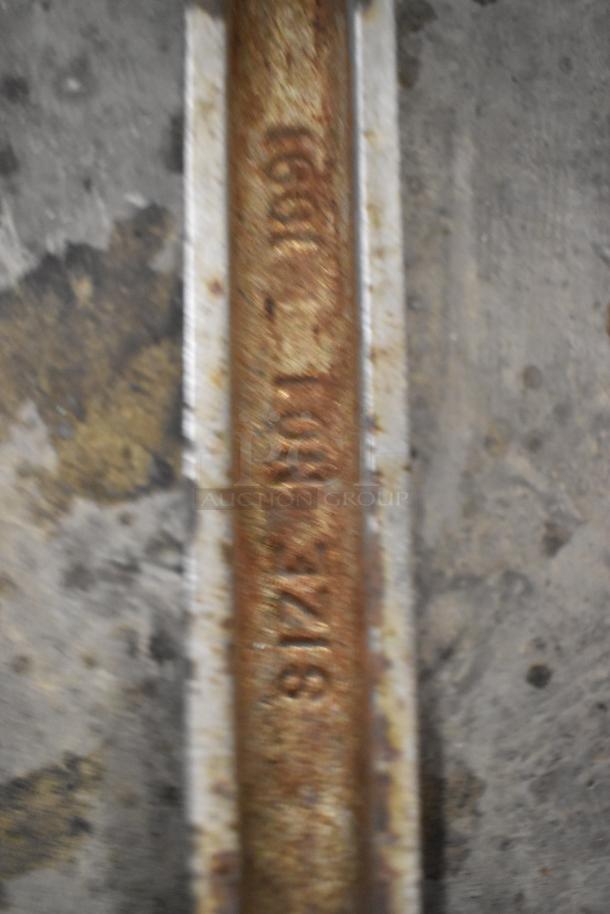 Rusty metal commercial can opener, marked with "818". Worn condition, suitable for industrial use or restoration.