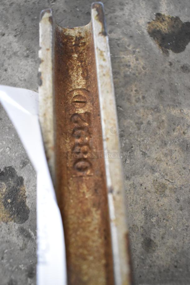 Rusted metal commercial can opener, detailed etching with "09220" visible. Sturdy construction, used condition.