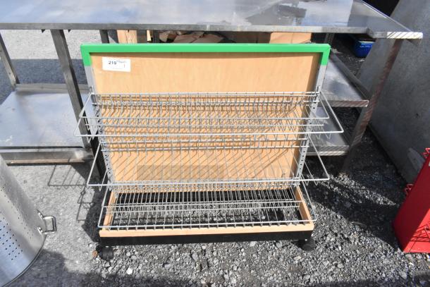 Merchandising rack on casters with metal wire shelves, wooden backing, and green trim. Label reads “219.”