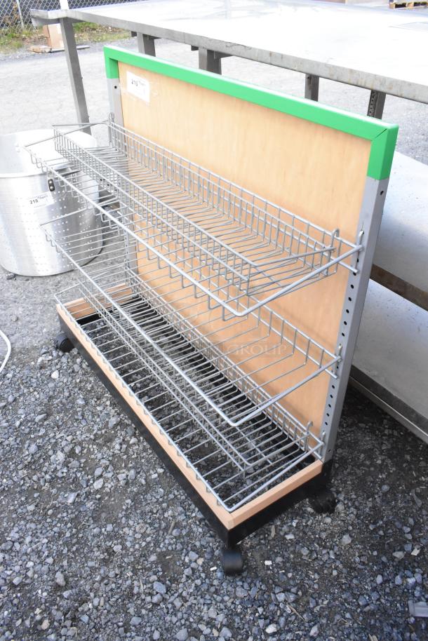 Merchandising rack on casters with three wire shelves, wood backing, and attached label with minor wear.